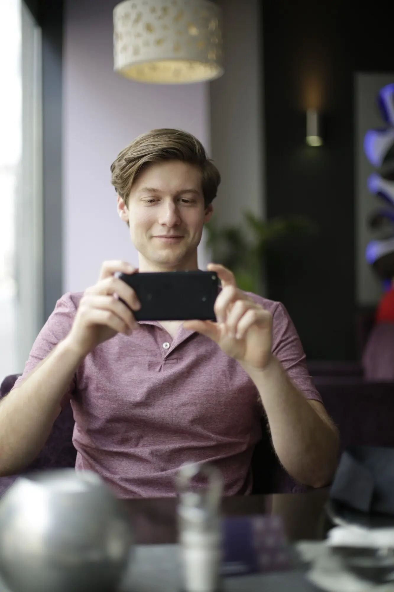 Toma vertical de un hombre tomando una foto con su teléfono.